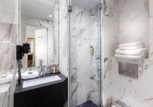 een badkamer met een wastafel en een douche bij Hôtel Du Bois Champs-Elysées in Parijs