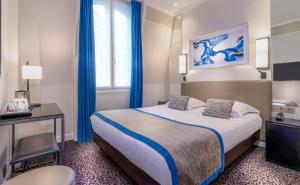 パリにあるオテル デュ ボワ シャンゼリゼのベッド、デスク、窓が備わるホテルルームです。