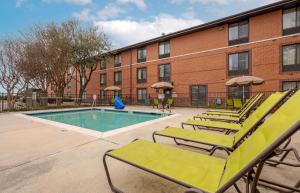 a swimming pool with lounge chairs and a building at Extended Stay America Suites - Austin - Metro in Austin