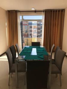 mesa de comedor con sillas y ventana grande en Apartamento 1 cómodo, en Cochabamba