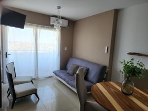 a living room with a blue couch and a table at TORRE MAFALDA 15 Departamento nuevo con Pileta in Río Cuarto +4 photos