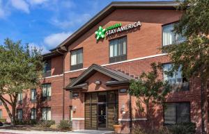 a red brick building with a star alliance sign on it at Extended Stay America Suites - San Antonio - Colonnade - Medical in San Antonio