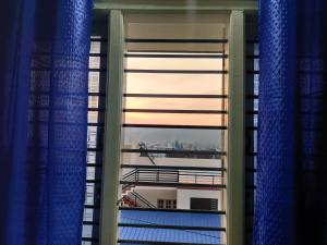 una ventana con vistas a un edificio y cortinas azules en Single haven 8431o31389 en Mysore