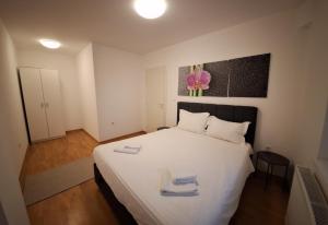 a bedroom with a white bed with two towels on it at Modern Living Apartments in Skopje
