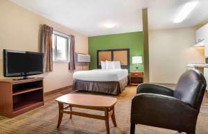 ein Hotelzimmer mit einem Bett und einem Flachbild-TV in der Unterkunft Extended Stay America Suites - Jackson - Ridgeland in Ridgeland
