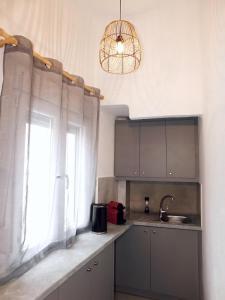 una cucina con lavandino e finestra di Thèros a Ermoupoli