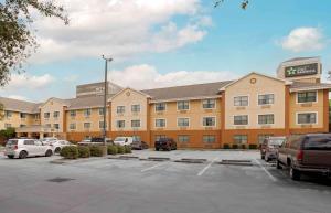 ein großes Gebäude mit Autos auf einem Parkplatz in der Unterkunft Extended Stay America Suites - Houston - Med Ctr - Greenway Plaza in Houston