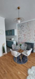 sala de estar con mesa y sillas y cocina en Luxury new apartament private parking, en Bucarest