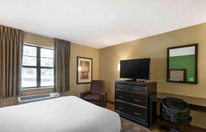 a hotel room with a bed and a flat screen tv at Extended Stay America Suites - Boise - Airport in Boise