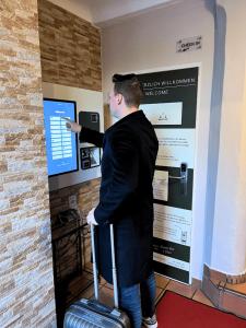 a man pointing at a computer screen with a suitcase at Hotel Blie, Bed & Breakfast, Self Check-in in Horn