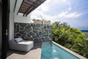 un patio con piscina y una silla y vistas al océano en Adults Only! Ocaso Luxury Villas Entire Property, en Rincón