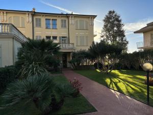 a large building with palm trees in front of it at Sweet home in Bordighera