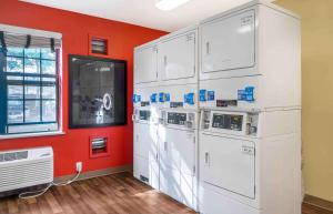 a room with four washer and dryers against a red wall at Extended Stay America Suites - Seattle - Everett - North in Everett