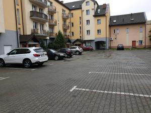 un aparcamiento con coches estacionados frente a los edificios en JDK Apartamenty Legionów 50m2 5-osobowy, en Kalisz