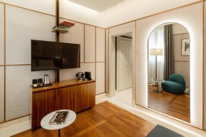 um quarto com uma televisão e um espelho em Hotel Brun em Bolonha
