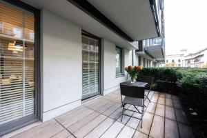 a patio with a table with a vase of flowers on it at Premium Apartments by Wawel Castle in Krakow