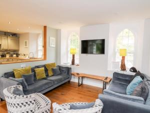 uma sala de estar com um sofá, cadeiras e uma mesa em Upper Vestry em Llandysul