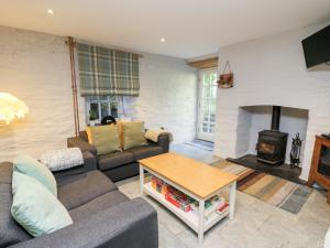 a living room with a couch and a fireplace at Lower Vestry in Llandysul