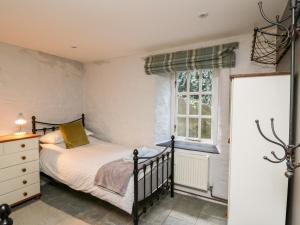 a bedroom with a bed and a window at Lower Vestry in Llandysul