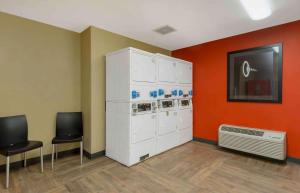 a room with orange walls and white cabinets and chairs at Extended Stay America Suites - Seattle - Kent in Kent