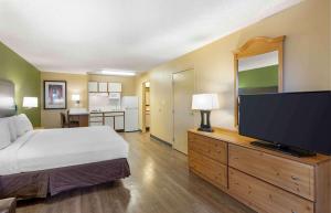 um quarto com uma cama e uma televisão de ecrã plano em Extended Stay America Select Suites - Denver - Cherry Creek em Denver