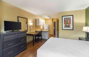 Habitación de hotel con cama y escritorio con TV. en Extended Stay America Suites - Denver - Park Meadows en Lone Tree