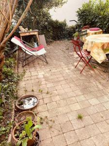 un patio con tavolo, sedie e piante di Maison d'une chambre avec jardin clos et wifi a Osny a Osny
