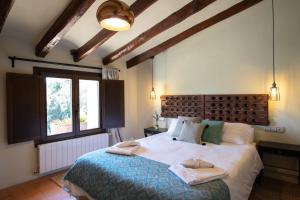 a bedroom with a large bed with towels on it at La Masia Alt Penedès in Pontons