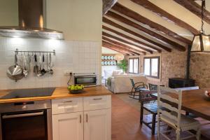 a kitchen with a table and a dining room at La Masia Alt Penedès in Pontons