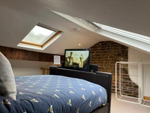 um quarto com uma cama e uma televisão num sótão em Bonsalls Central Hebden Bridge em Hebden Bridge