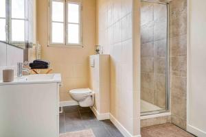 een badkamer met een douche, een toilet en een wastafel bij Appartement dans résidence calme, proche de Paris in La Garenne-Colombes