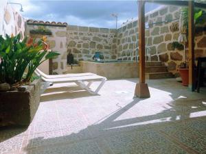 un banco blanco sentado en un patio con un edificio en Live Arico Lagar, en Arico el Nuevo