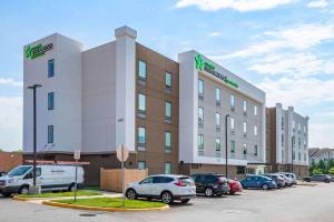 un gran edificio con coches estacionados en un estacionamiento en Extended Stay America Suites - Colonial Heights - Fort Lee, en Colonial Heights