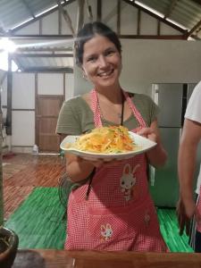 a woman is holding a plate of pasta at YaoIsland Resort and Farm in Ko Yao Yai