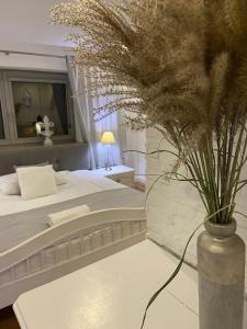 um quarto com uma cama e um vaso com flores sobre uma mesa em Apartament Skandynawski em Nowe Worowo