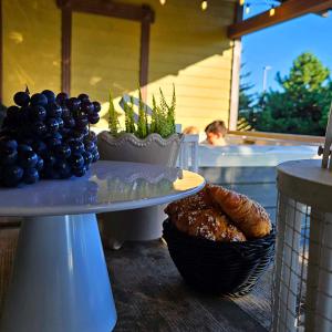 a table with a plate of grapes and a basket of bread at Resort Baure in Palanga