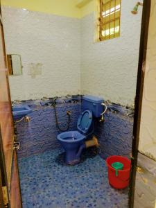 亞蘭博的住宿－Shree Sai Beach Stay，一间带蓝色卫生间和桶的浴室