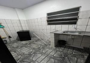 un baño sucio con lavabo y ventilador en Residencial Margarida APART 1 en Presidente Figueiredo