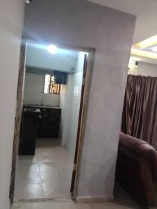 a mirror on a wall in a room with a kitchen at Fairways Apartments in Otta