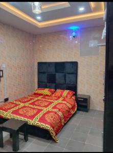 a bedroom with a red bed with a black headboard at Fairways Apartments in Otta