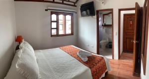 1 dormitorio con 1 cama y baño en Hospederia Villa de los Sáenz, en Villa de Leyva