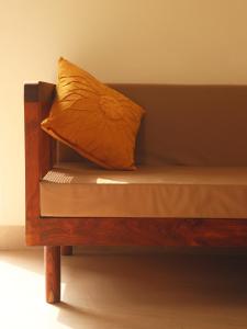 uma cama de madeira com uma almofada em cima em The Bageecha em Vrindavan