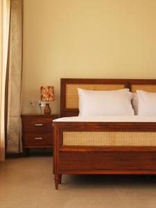 um quarto com uma cama e uma mesa de cabeceira com um candeeiro em The Bageecha em Vrindavan