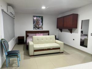 a bedroom with a white couch and a bed at Hotel COOL HOUSE 24Horas in Arauca