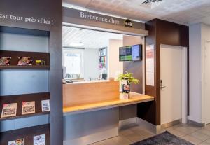 a reception desk in a restaurant with a sign that readsinephrine clinic at B&B HOTEL Limoges Centre Gare in Limoges