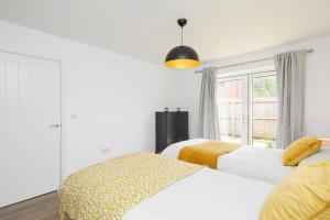2 camas en una habitación blanca con ventana en Derby Train Station Roof Terrace House en Derby