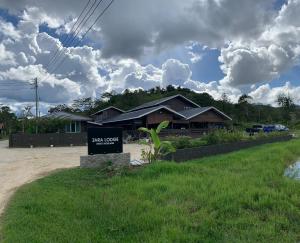 a house with a sign in front of it at Zara Lodge in Bario