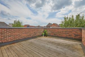 a brick wall with a wooden floor and a wooden deck at Derby Train Station Roof Terrace House in Derby