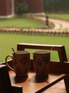 twee koffiekopjes bovenop een tafel bij The Bageecha in Vrindāvan