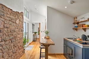 a kitchen with a stone wall and a wooden table at Finest Retreats - Hillfarrow Hideaway in Tiverton